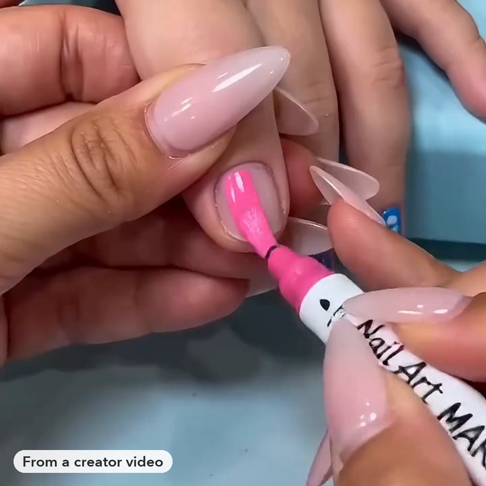 Frame from a creator video: the brush tip coloring a nail pink
