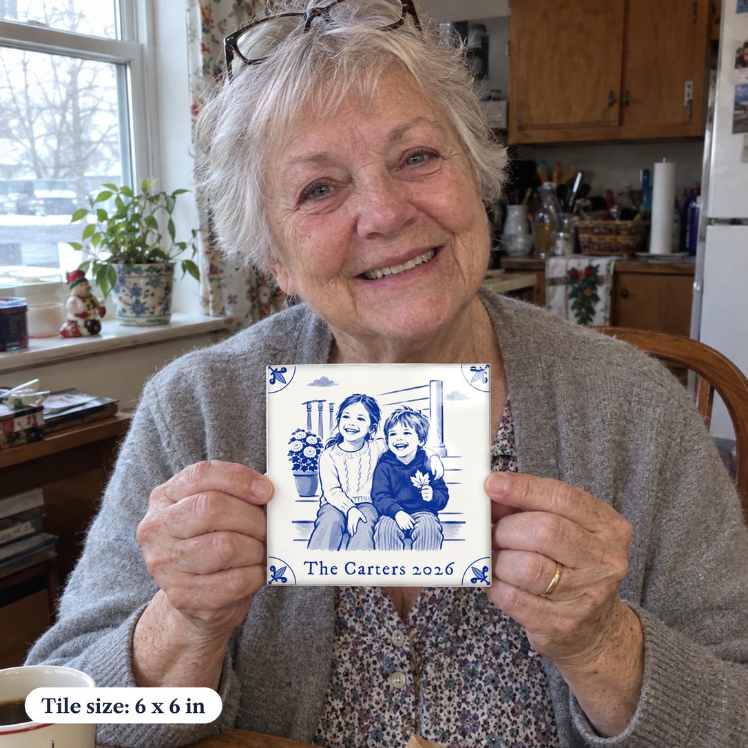 A grandmother at her kitchen table holding up a Delft-blue tile of her grandchildren