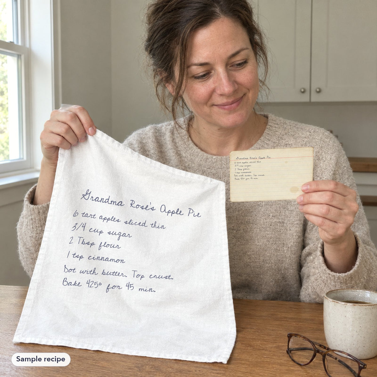 A woman holding her family recipe card next to the printed tea towel