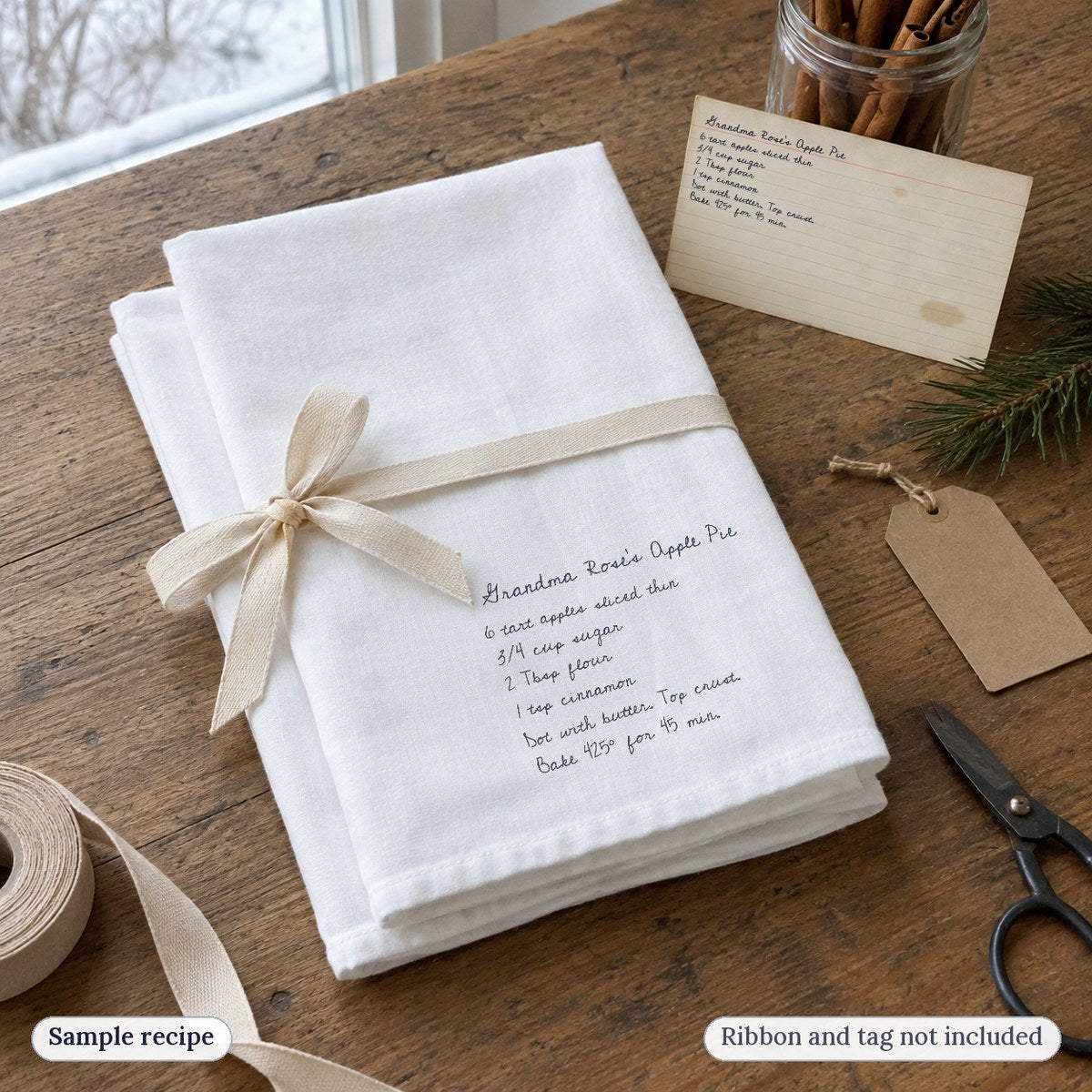 Two folded recipe tea towels tied with a ribbon next to the recipe card (ribbon and tag not included)