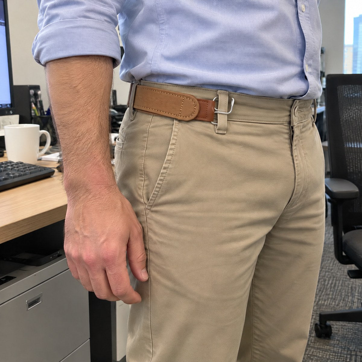 Brown strap at the hip of khaki chinos with a tucked shirt