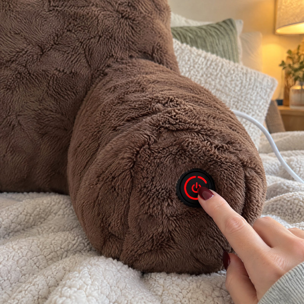 Finger pressing the armrest power button, its ring glowing red