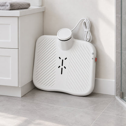 Body dryer stored upright against the bathroom wall next to the vanity, cord coiled