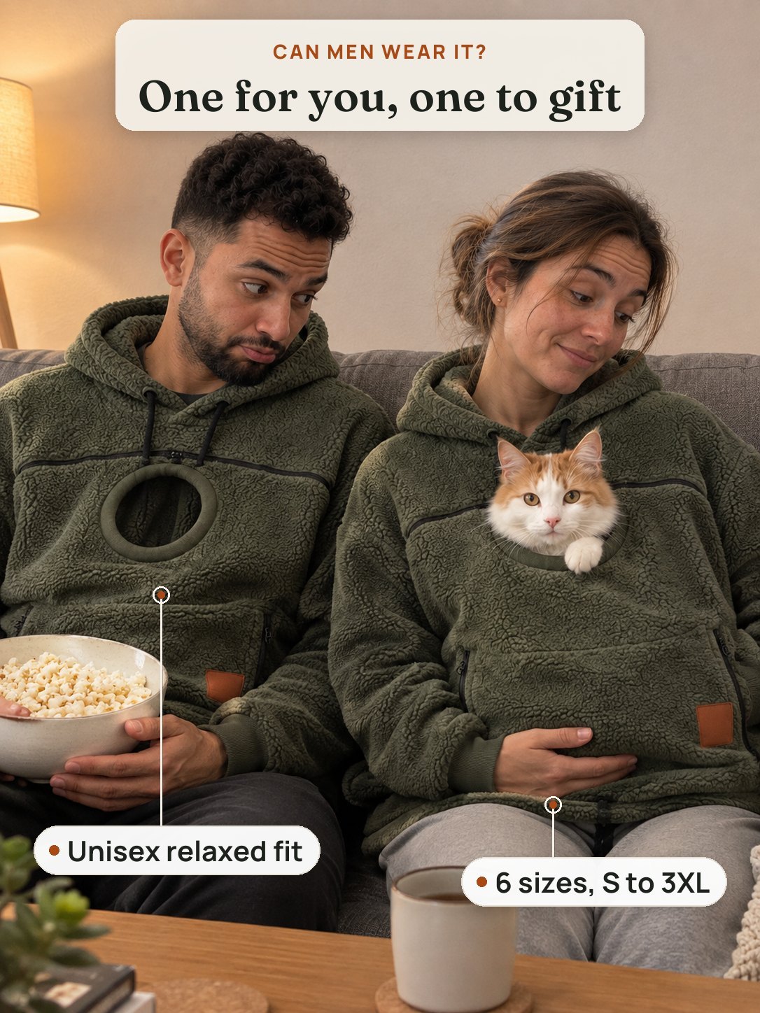 A couple on the sofa in matching olive cat pouch hoodies, the cat peeking out of hers while he pretends to be jealous