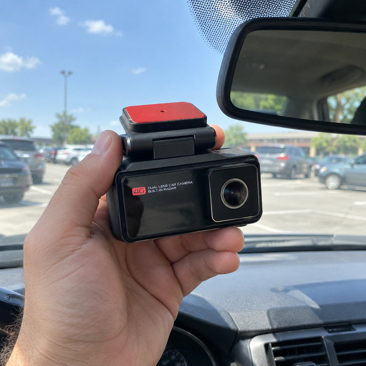 Holding the 4G car camera up to the windshield before mounting it
