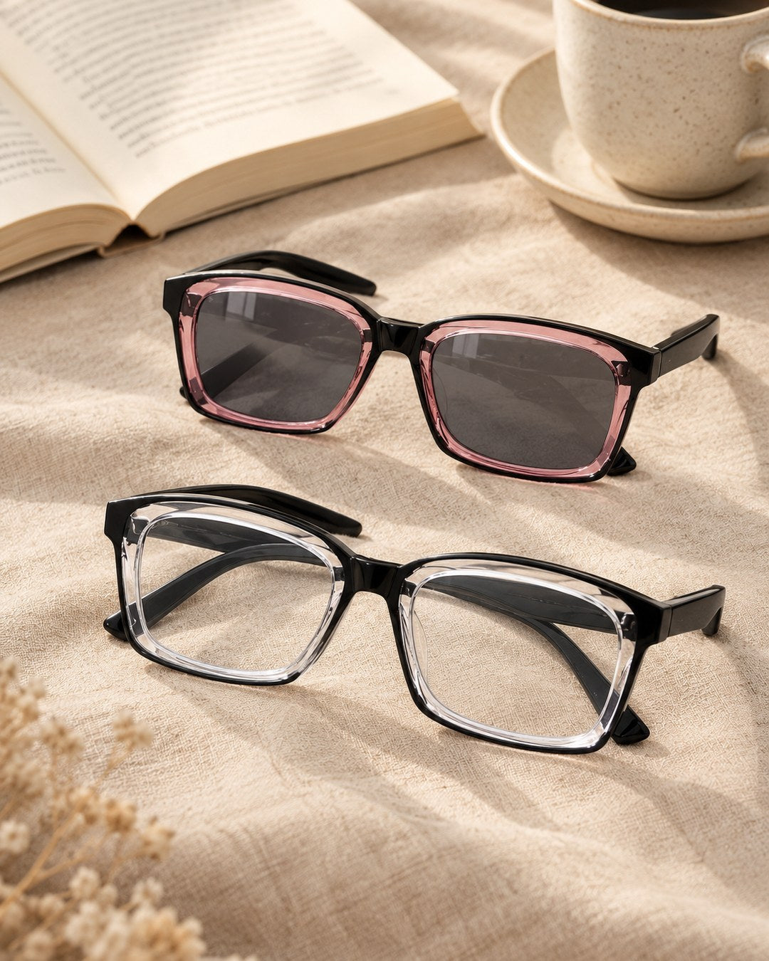 Two pairs of the reading glasses on linen: one with clear lenses, one with lenses tinted like sunglasses