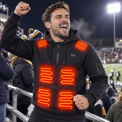 Man cheering in the stands of a football game on a cold night, wearing the heated hoodie