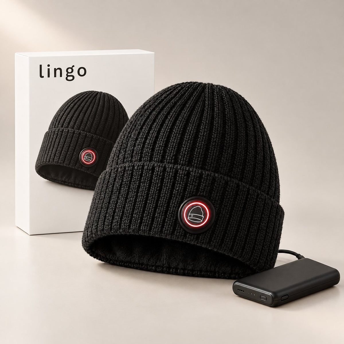 Heated beanie with its button glowing red, its battery and the lingo box