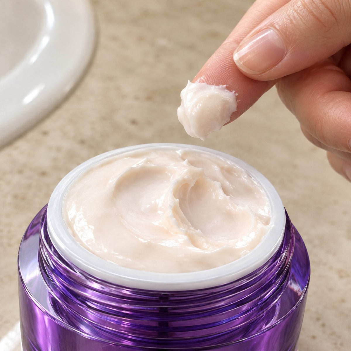 Fingertip lifting the thick whipped cream from the jar