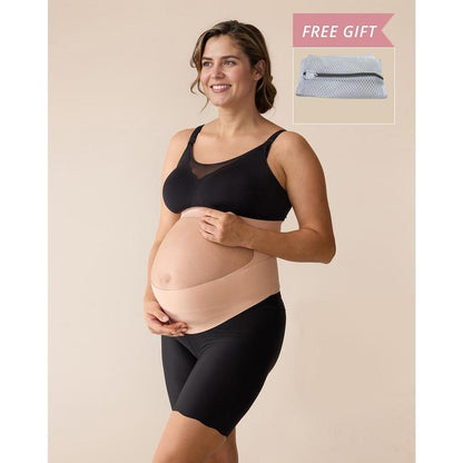 Pregnant woman wearing the nude maternity support band, with a band under the bump and a band above it, and the free zip mesh laundry bag