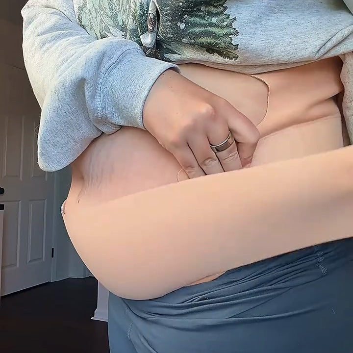 Close-up of a woman closing the nude band under her bump