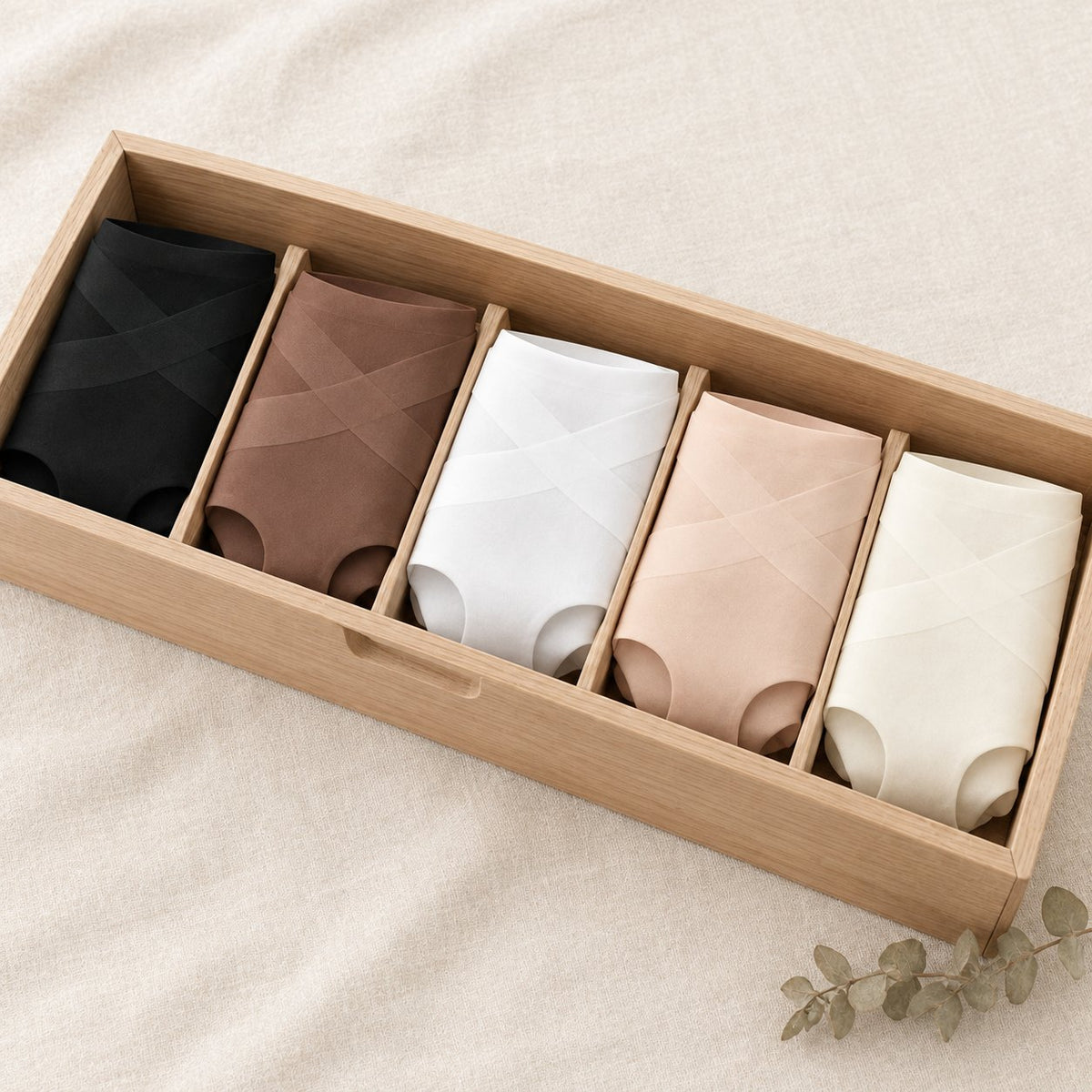 Five No Show briefs folded in a drawer, one of each color: black, mocha, white, nude and ivory