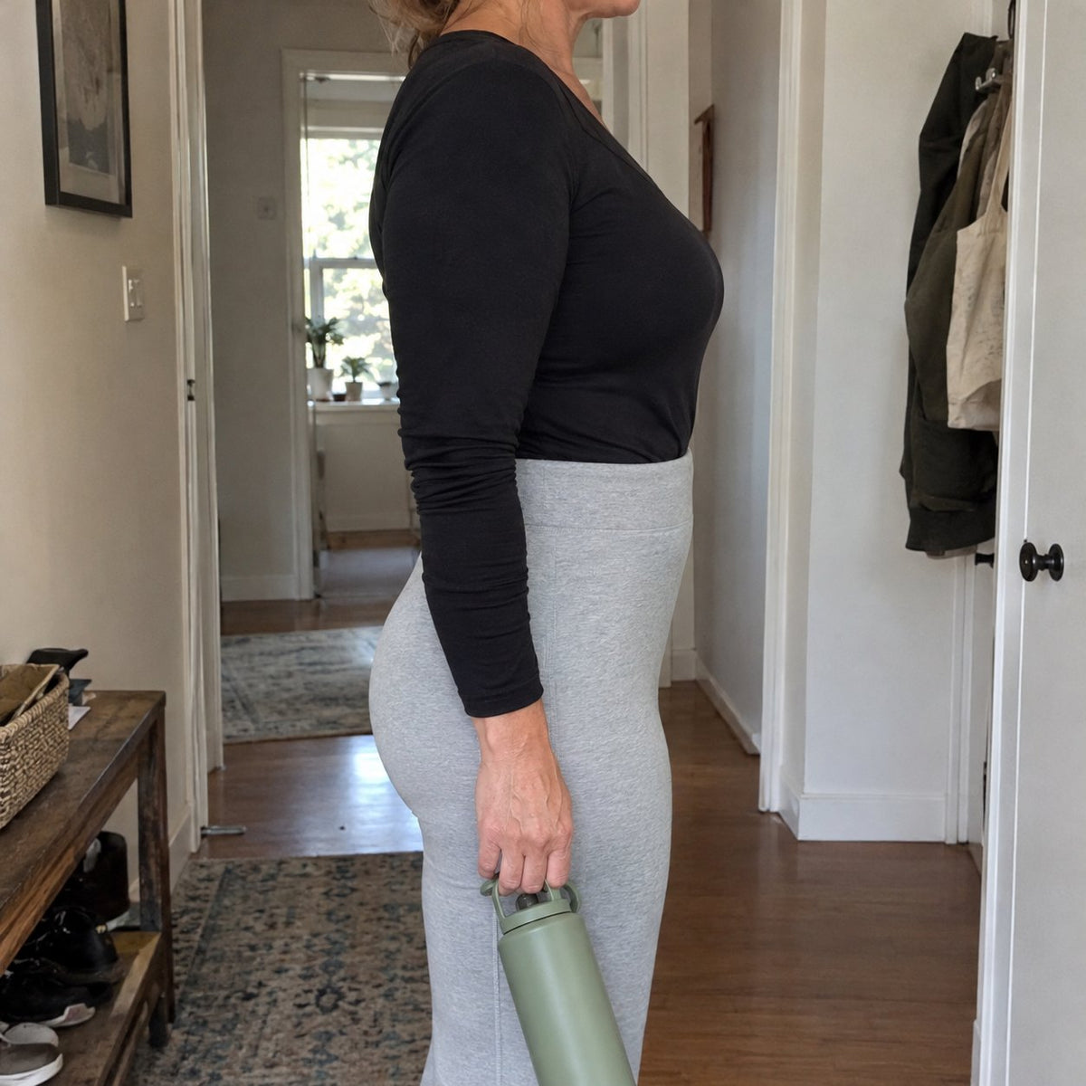 Side view of a woman in thin grey leggings: smooth lower belly, no underwear lines