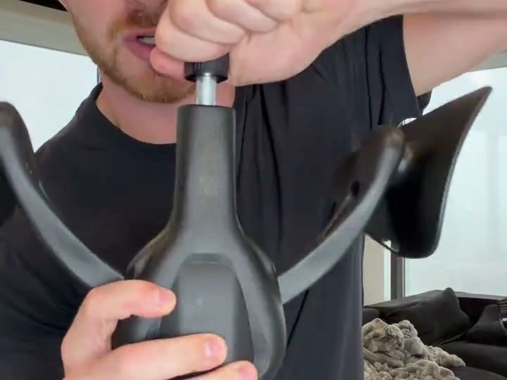 A fist turning the knob on top of the trainer to make it harder