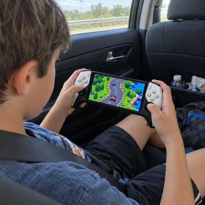 A boy plays the retro console in the back seat on a road trip