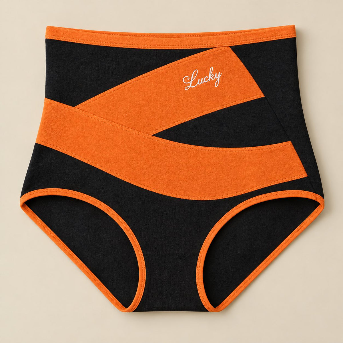 Front of the shaping brief: black knit with a wide crossed orange band and orange trim