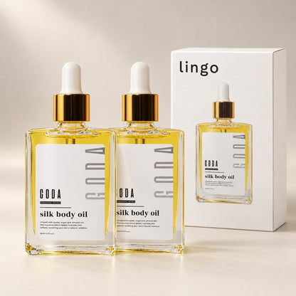 Two bottles of Silk Body Oil with the lingo box