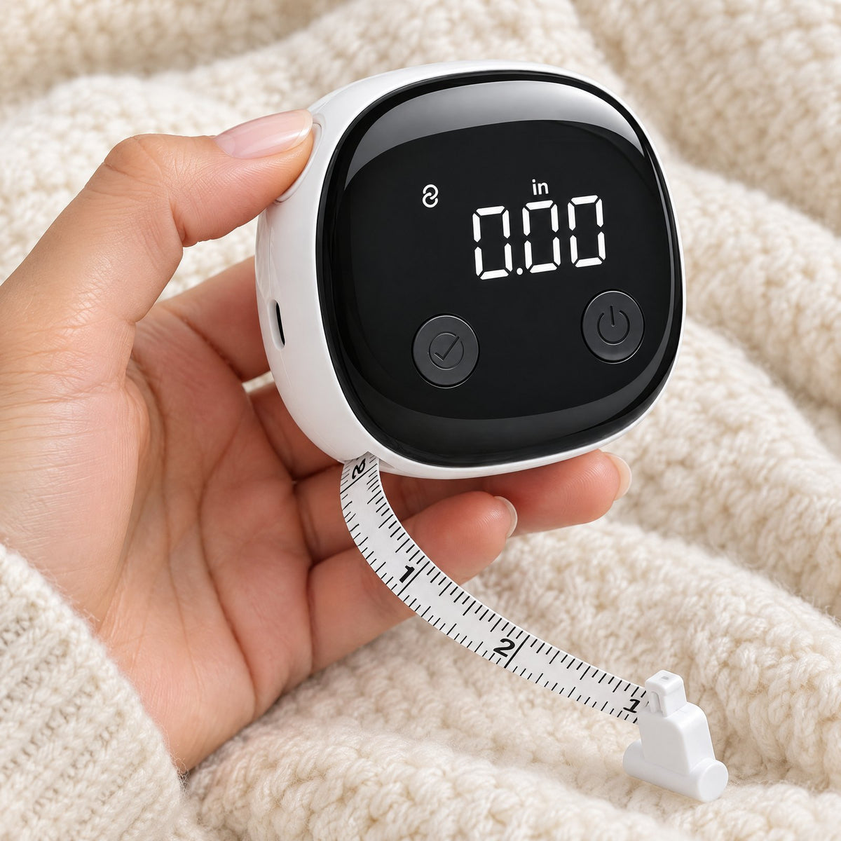 Hand holding the smart tape measure while the tape winds back in, screen showing 0.00 in