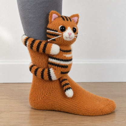 Orange knit sock with a 3D knitted orange tabby cat hugging the ankle
