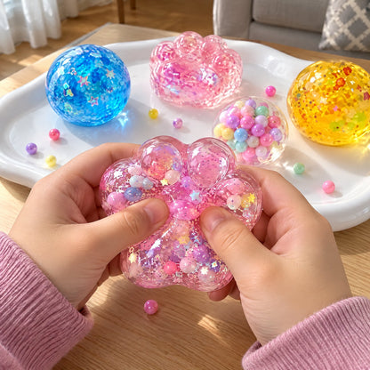 Child squeezing a clear glitter cat-paw squishy full of beads