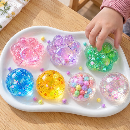 Row of handmade squishies: paws and balls with beads and glitter