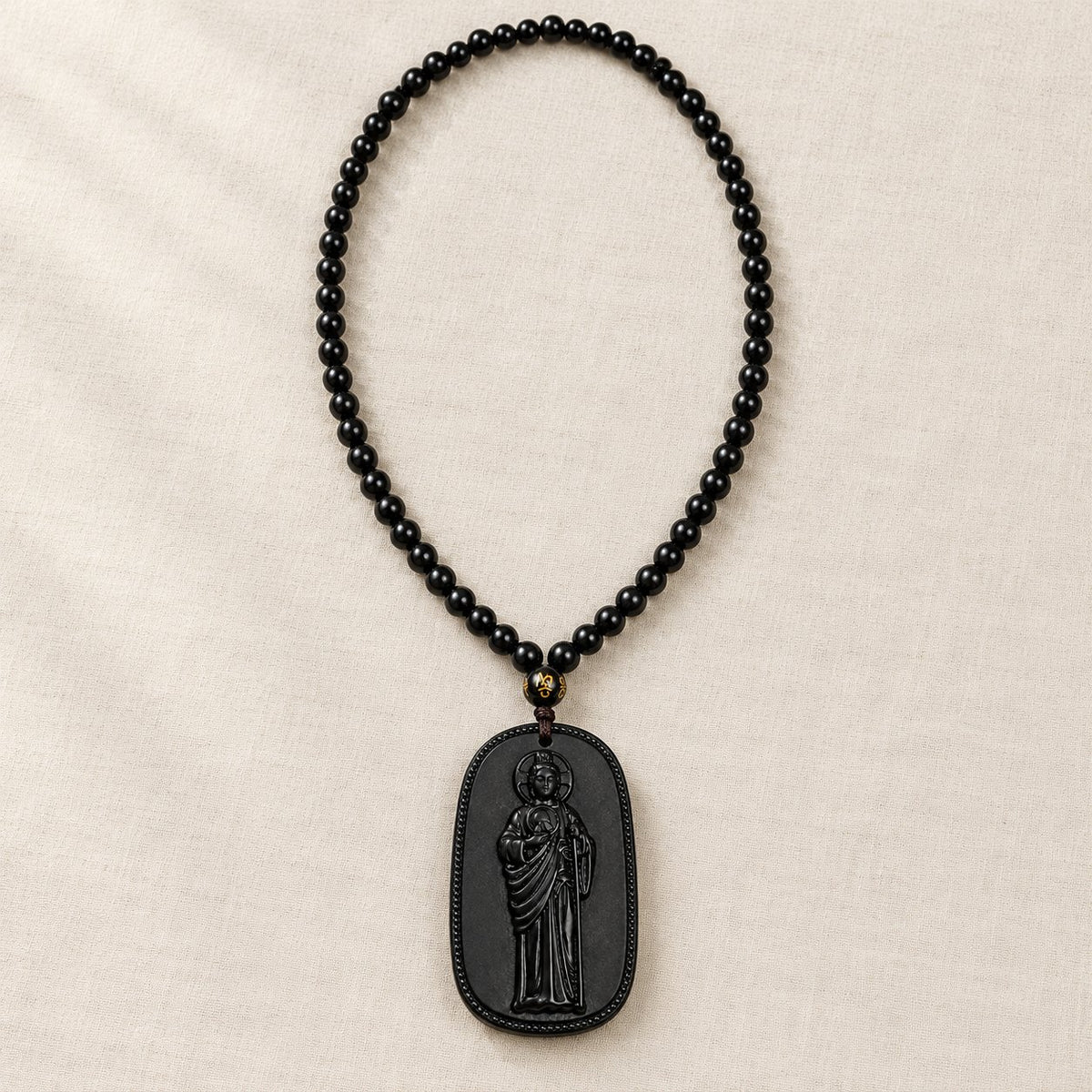 El collar de San Judas Tadeo completo: dije de piedra tallada y cadena de cuentas negras