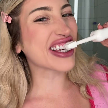 Woman brushing her teeth with the white roller toothbrush in her bathroom