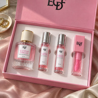 Open pink gift box holding a 30 ml pink perfume with a cream cap, two 10 ml roll-on elixirs and a pink lip gloss