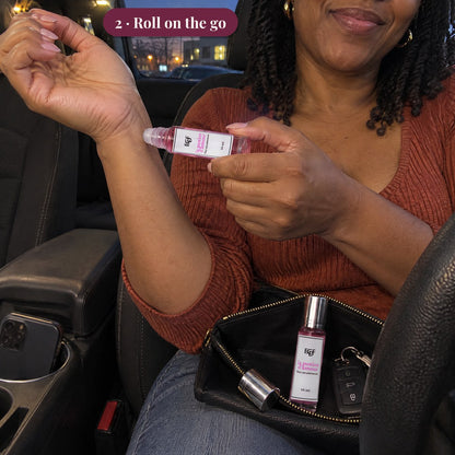 Woman in a parked car rolling a roll-on elixir on her wrist, her clutch open on her lap