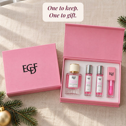 Two pink gift sets on a table, one closed and one open showing the perfume, two roll-ons and the gloss