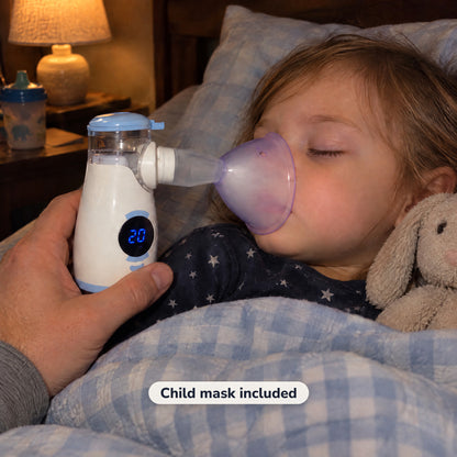 Sleeping child with the child mask attached directly to the handheld nebulizer, lamp light