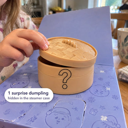 A child lifting the lid of the steamer-style case that hides the surprise dumpling